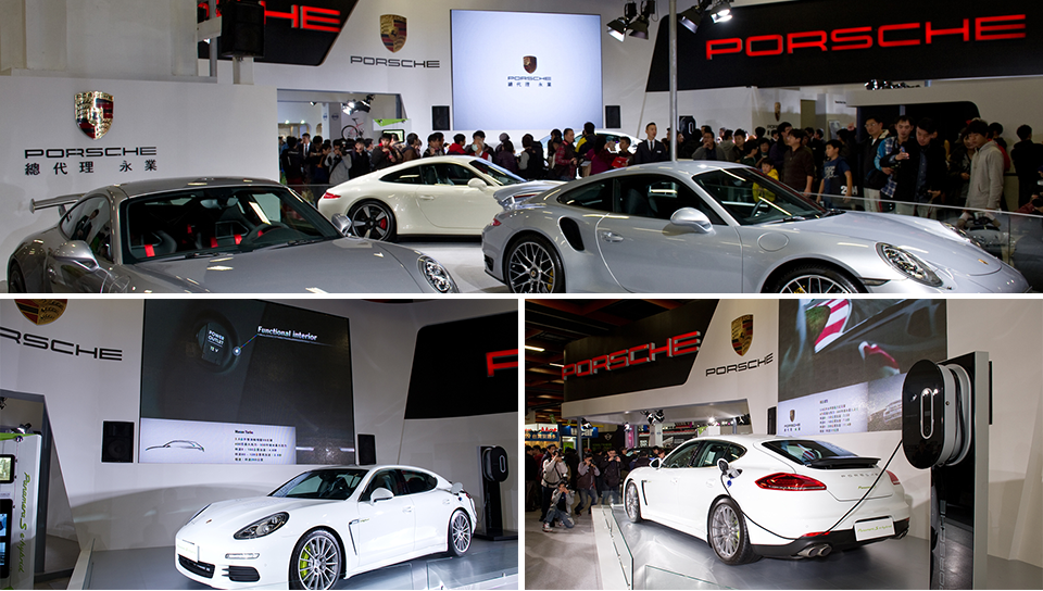 Porsche models staged on a white-and-silver show stage under tight lighting